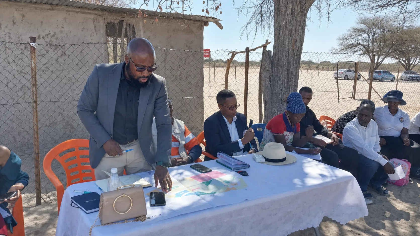 Planning team reviewing drawings at an outdoor consultation table